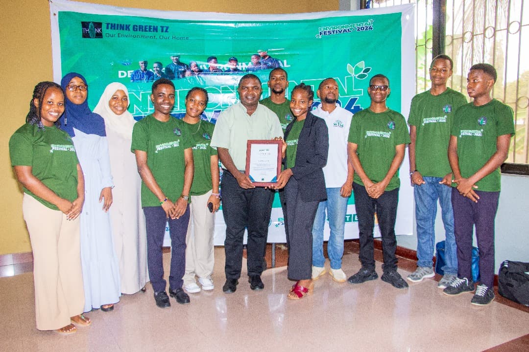 Think Green team members in green shirts holding a certificate at the Environmental Festival